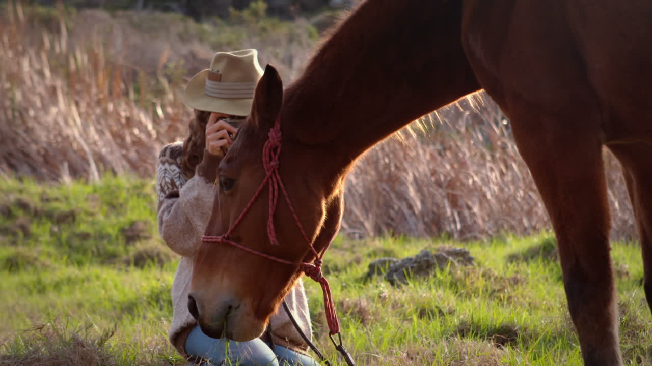 una mujer bonita tomando fotos de un caballo.