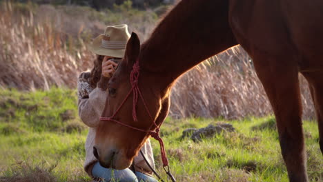 pretty woman taking pictures of a horse