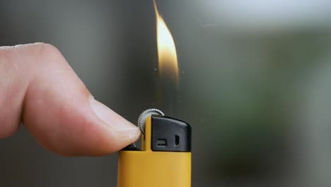 hand lights the lighter. blazing lighter in hand on super slow motion.