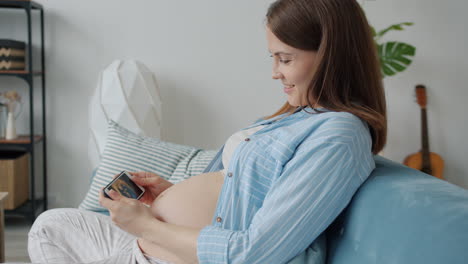 pregnant woman viewing ultrasound image on smartphone