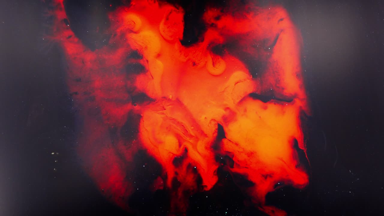 Alcohol ink flows and mixes in vivid red and black swirls, macro abstract art