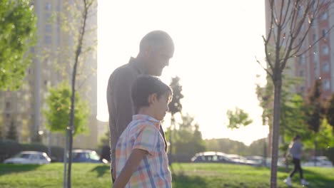 el abuelo está caminando y caminando afuera con su nieto.