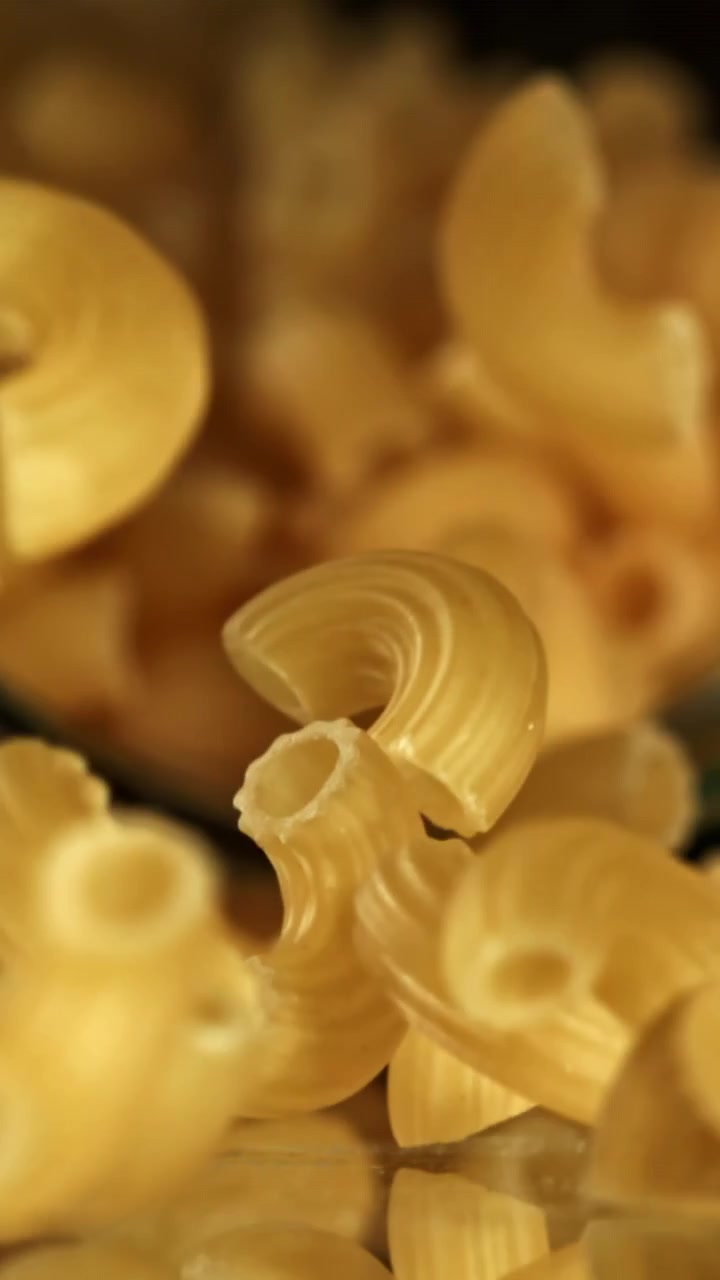 Pasta maccheroni dorata che cade al rallentatore
