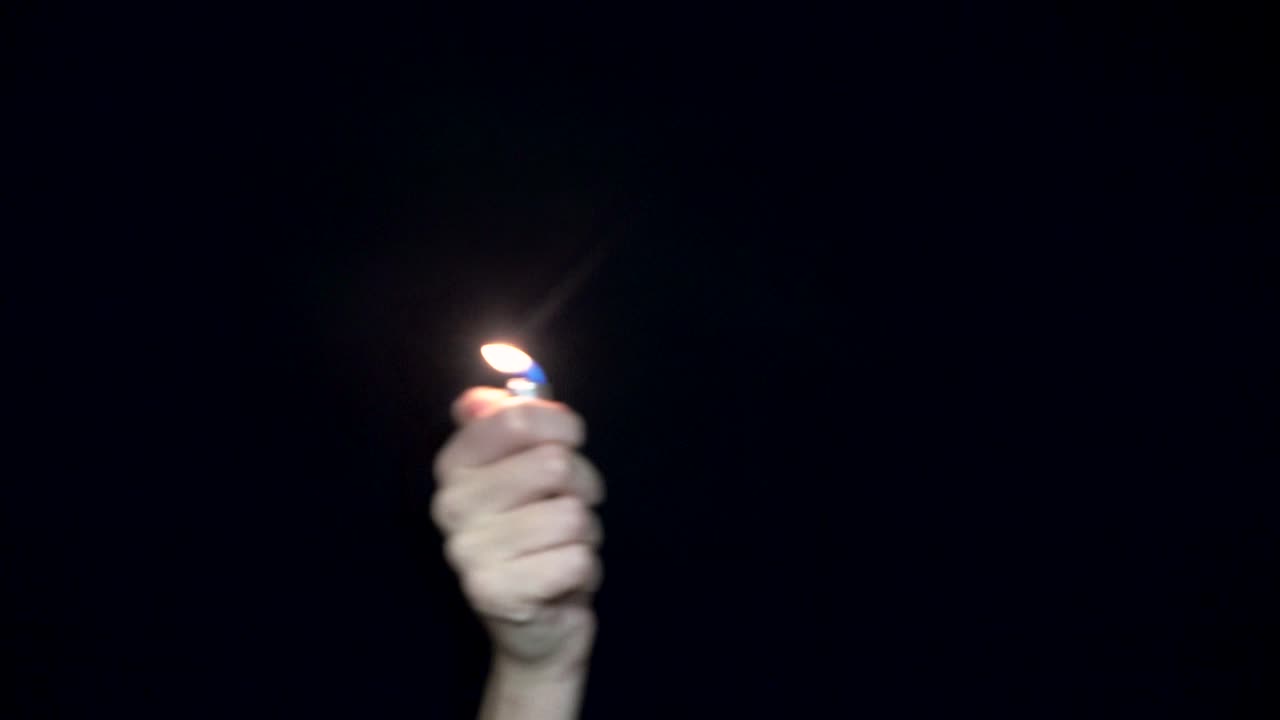 Hand holding a lighter with a flame