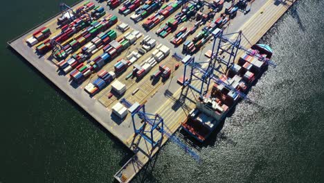 container ship loading at port with crane, container ship carrying container import and export business logistic and transportation, aerial top view.