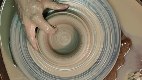 woman hands on pottery wheel. craftsman artist shapes pot