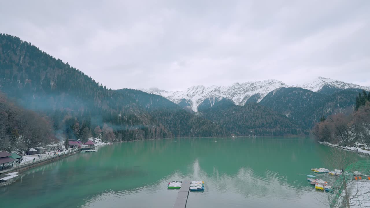 lago de montaña nevado con turistas