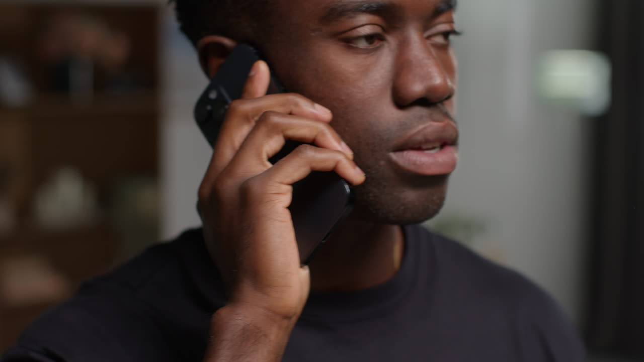 primer plano de un joven infeliz y deprimido en casa terminando la llamada después de hablar por teléfono móvil