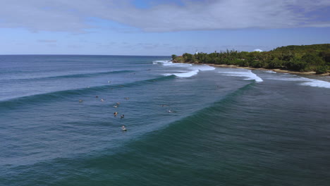 Drohne-Hält-Still,-Während-Sie-Surfer-Filmt,-Die-An-Einem-Klaren-Tag-Mit-Blauem-Himmel-In-Der-Nähe-Von-Rincon-Puerto-Rico-Im-Ozean-Schwimmen