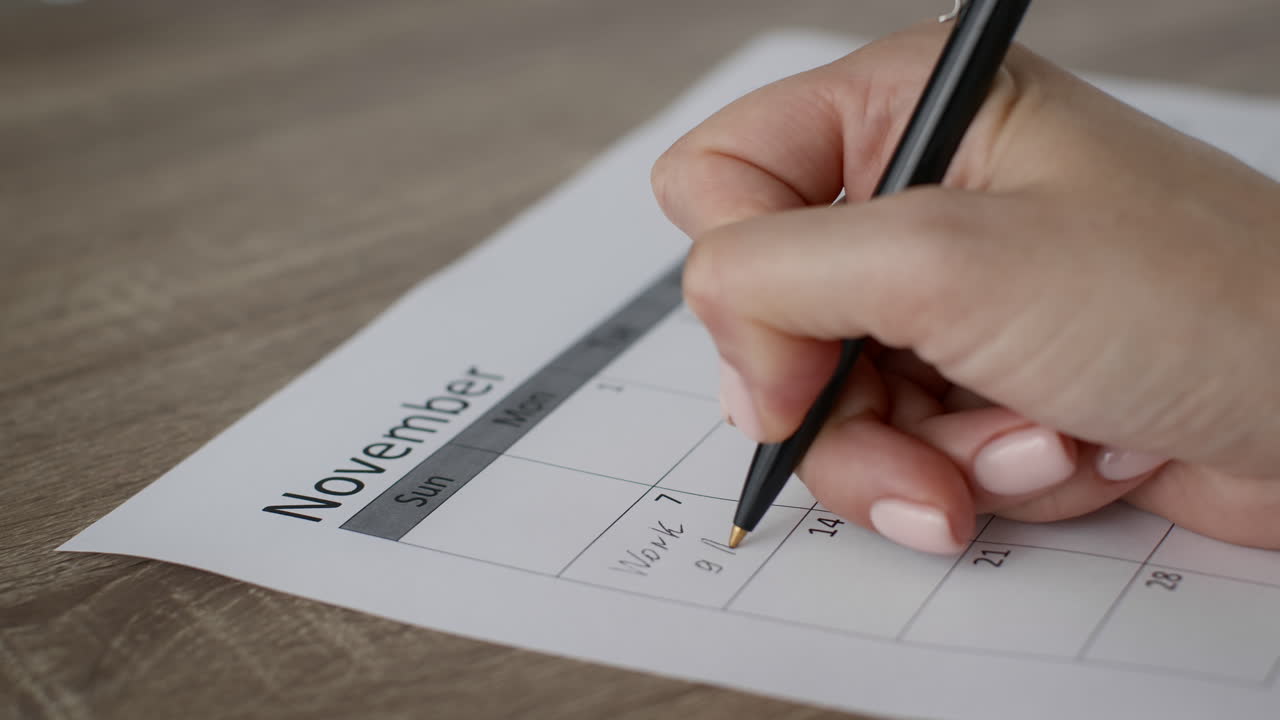 mujer escribiendo en un calendario de noviembre