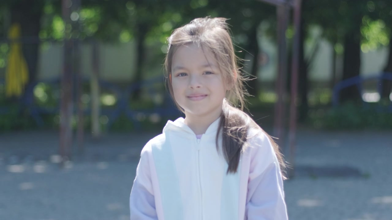 公園でカメラに笑顔を向ける可愛らしい少女