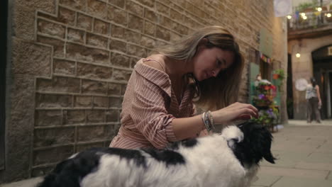 happy woman stroking dog outdoor in slow motion. smiling woman hugging doggy