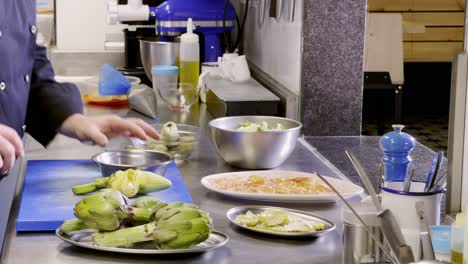 Professional-cook-prepares-artichokes-in-restaurant's-kitchen