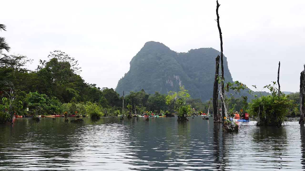 카야크 타는 사람 들 은 산 을 배경 으로 하여 은 물 을 항해 한다