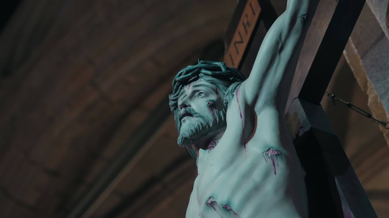 painted statue of jesus on the cross with visible wounds inside church