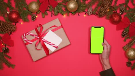 teléfono de mano, decoraciones de navidad y caja de regalos
