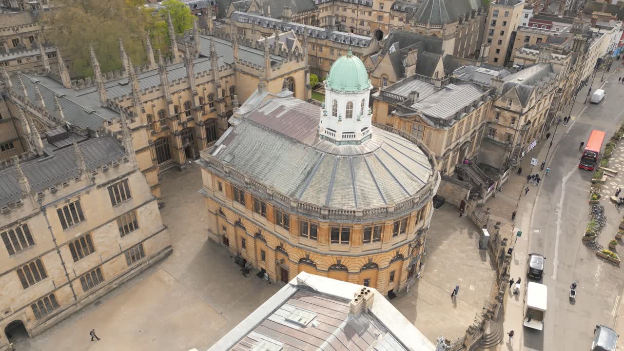drone flying around the Sheldonian Theatre, bright sunlight shines on the building