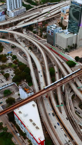cars move by the multiple freeways in the metropolis downtown. cityscape of miami, florida, usa from top. vertical video