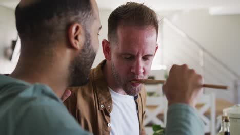 Multi-ethnic-male-same-sex-couple-preparing-food-in-kitchen