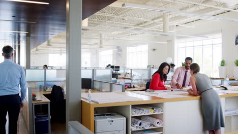 three architects working together in busy open plan office