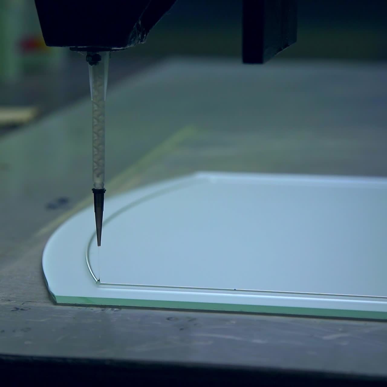 Applying lines picture on the glass elements of door. Machine moves and leaves a thin line on the glass. Door manufacturing plant