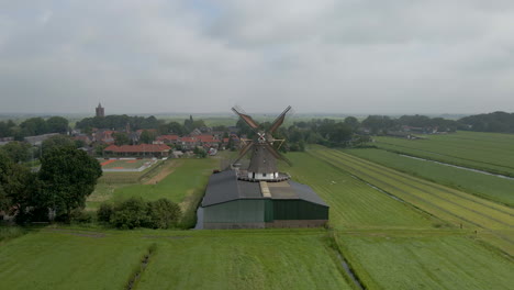 Jib-Up-De-Molino-De-Viento-Giratorio-Con-Un-Pequeño-Pueblo-Rural-En-El-Fondo