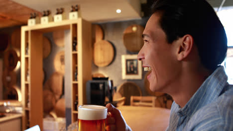 smiling man having a glass of beer 4k