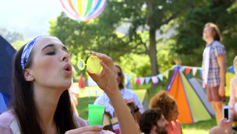 hipster woman doing soap bubble with a toy