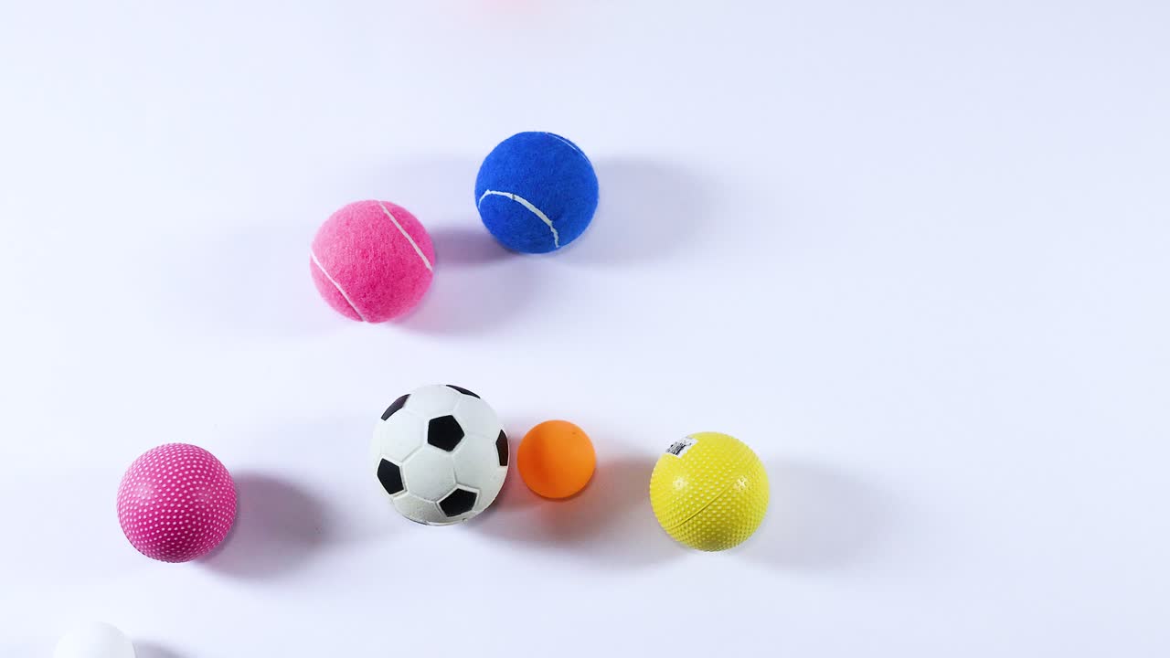 Various balls moving across a white background