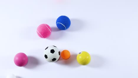 various balls moving across a white background