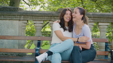 Same-Sex-Female-Couple-Sightseeing-Around-Oxford-UK-Sitting-On-Bench-And-Hugging