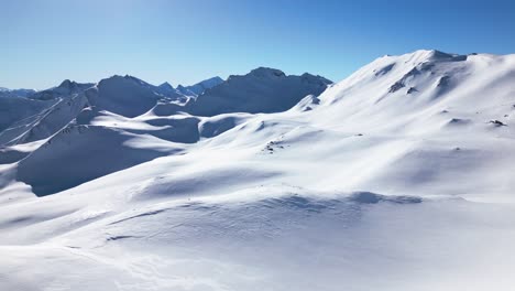 Eine-Wunderschöne-Weiße-Winterlandschaft-Mit-Großen-Bergen-Und-Blauem-Himmel