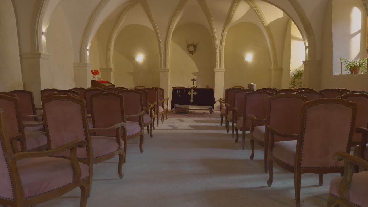Interno tranquillo di una cappella storica con sedie di legno e illuminazione soffusa