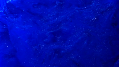 abstract blue paint splatter background with smokey ink in liquid water slow motion