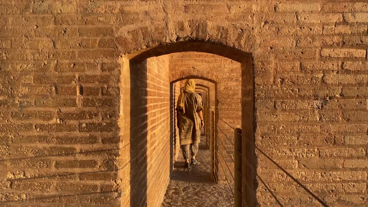 una hermosa supermodelo persa está caminando por un corredor en si-o se pol esfahan, la capital histórica cultural del imperio safávida, diseño de arquitectura de ladrillo en el río zayande roud en irán