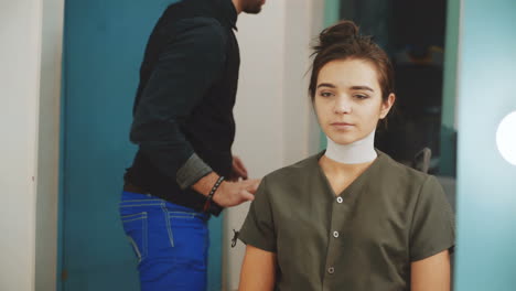 Hairdresser during work with beautiful woman client. Beauty industry concept