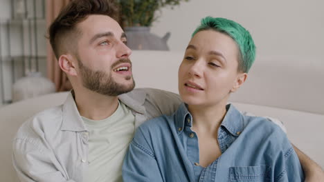 happy couple talking together while sitting on the floor at home