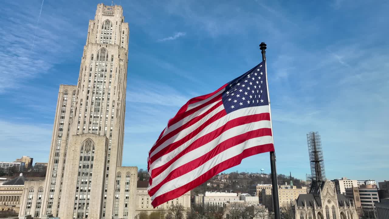Bandiera americana che sventola accanto alla Cathedral of Learning all'Università di Pittsburgh in Pennsylvania