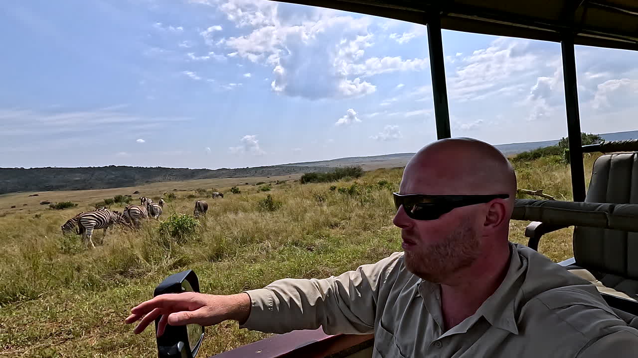 Safari guide explains wildlife to tourists on safari in African wilderness