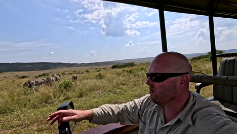 safari guide explains wildlife to tourists on safari in african wilderness