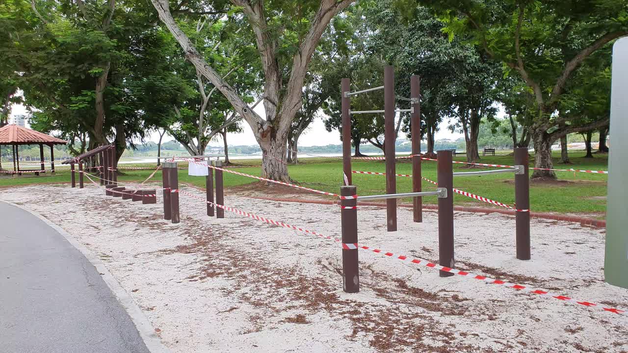 Workout static stations with barrier tape and warning sign during Covid-19 lockdown in a public park in Singapore, Asia