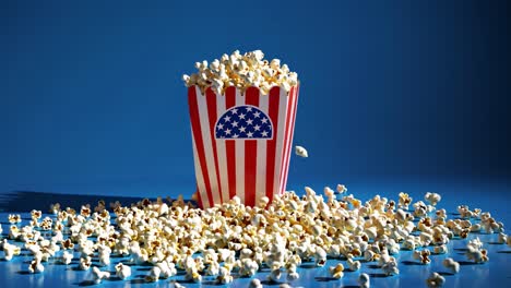 popcorn exploding from a red and white striped box with the usa flag on it, against a vibrant blue background, creating a dynamic and celebratory scene