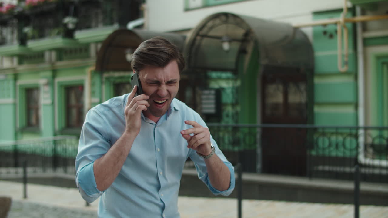길거리에서  ⁇ 드폰으로 춤을 추는 흥분된 남자. 승리를 축하하는 즐거운 사업가