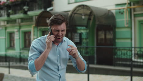 hombre emocionado bailando con el teléfono en la calle. hombre de negocios alegre celebrando la victoria