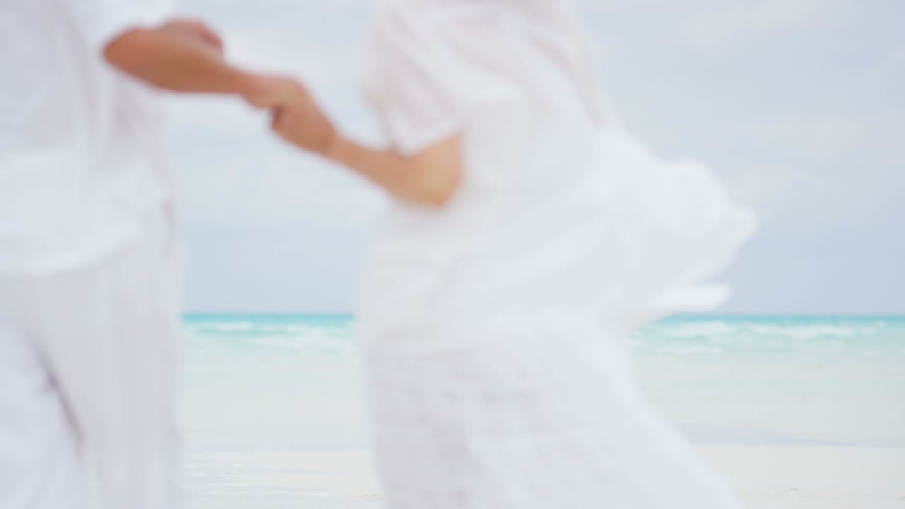 pareja caucásica madura descalza en la playa con una maleta