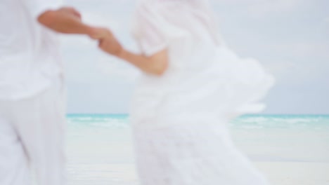 barefoot mature caucasian couple on beach with suitcase