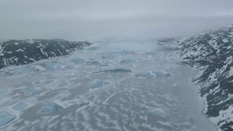 Glacier-and-Icebergs-in-Frozen-Glacial-Lake,-Drone-Shot,-Cold-Winter-Landscape-of-Iceland