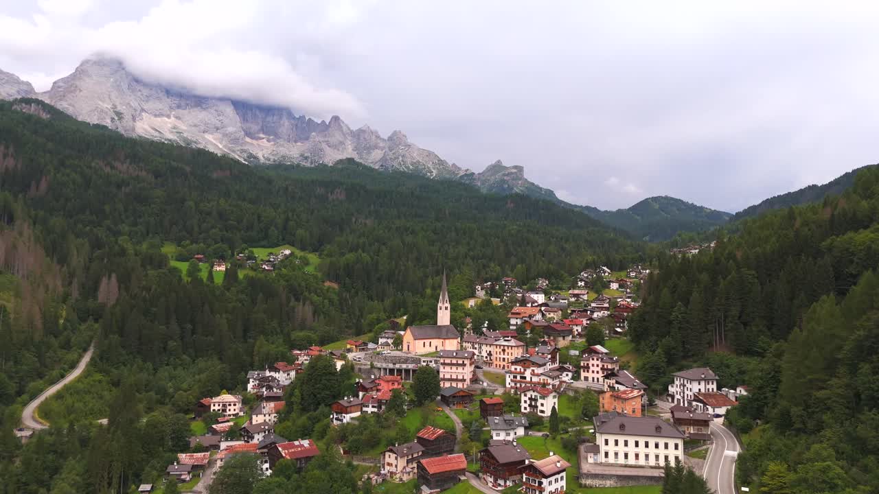 Snow-capped peaks tower over the quaint town, creating a breathtaking contrast of nature and civilization.