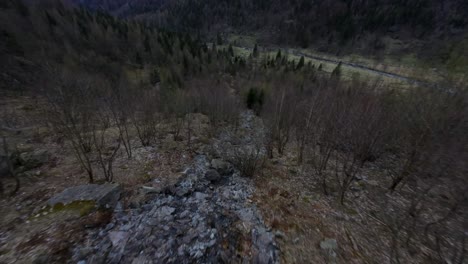 Vista-De-Drones-Fpv-Descendiendo-Sobre-La-Superficie-Rocosa-De-Una-Corriente-De-Agua-En-Val-Di-Mello-En-El-Norte-De-Italia