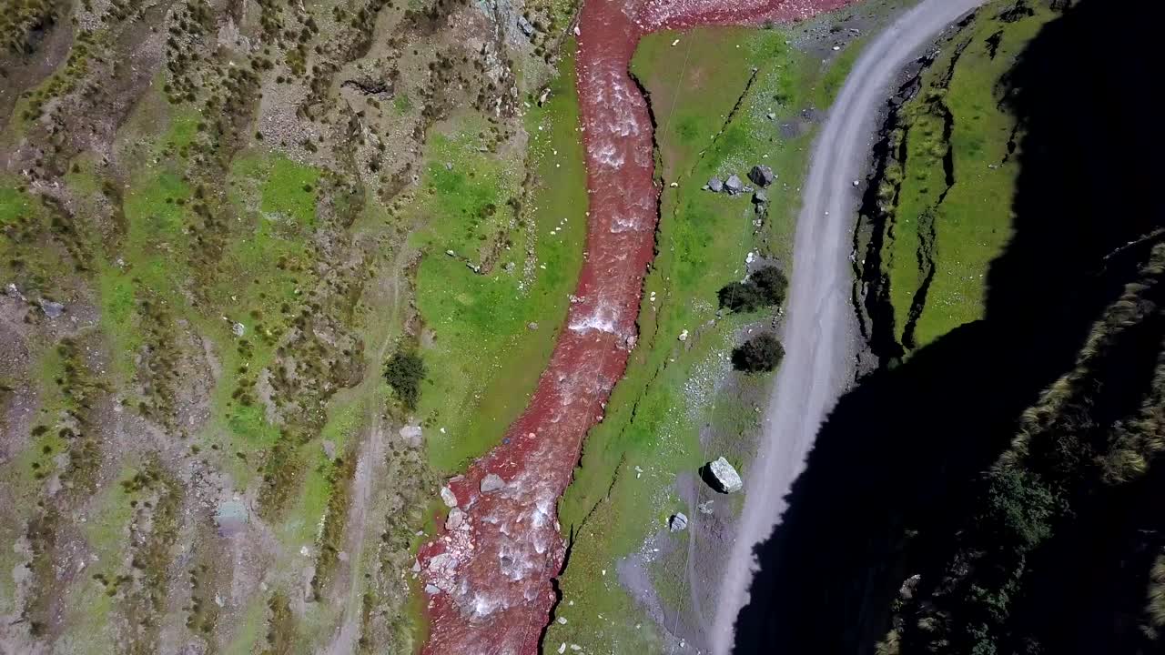 aéreo, de arriba hacia abajo, drone disparó sobre el río rojo pukamayu, en un día soleado, en cusco, perú, la américa del sur